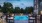 Large sparkling blue pool with a large pool deck and lounge chairs